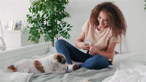 Teenage Girl Having Fun With Her Dog In Bedroom